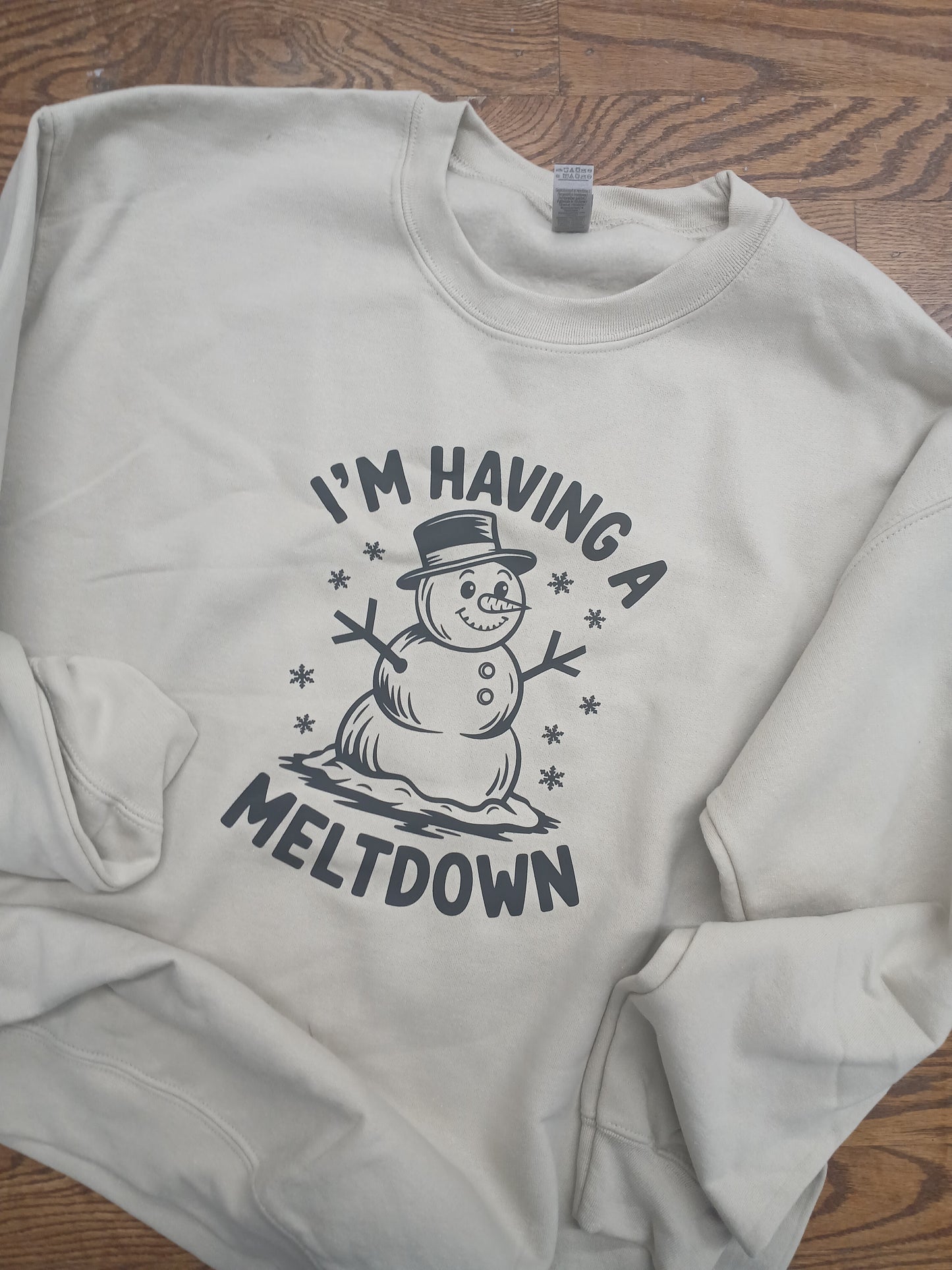 Sand colored sweatshirt with a snowman graphic and "I'm havingg a meltdown" text