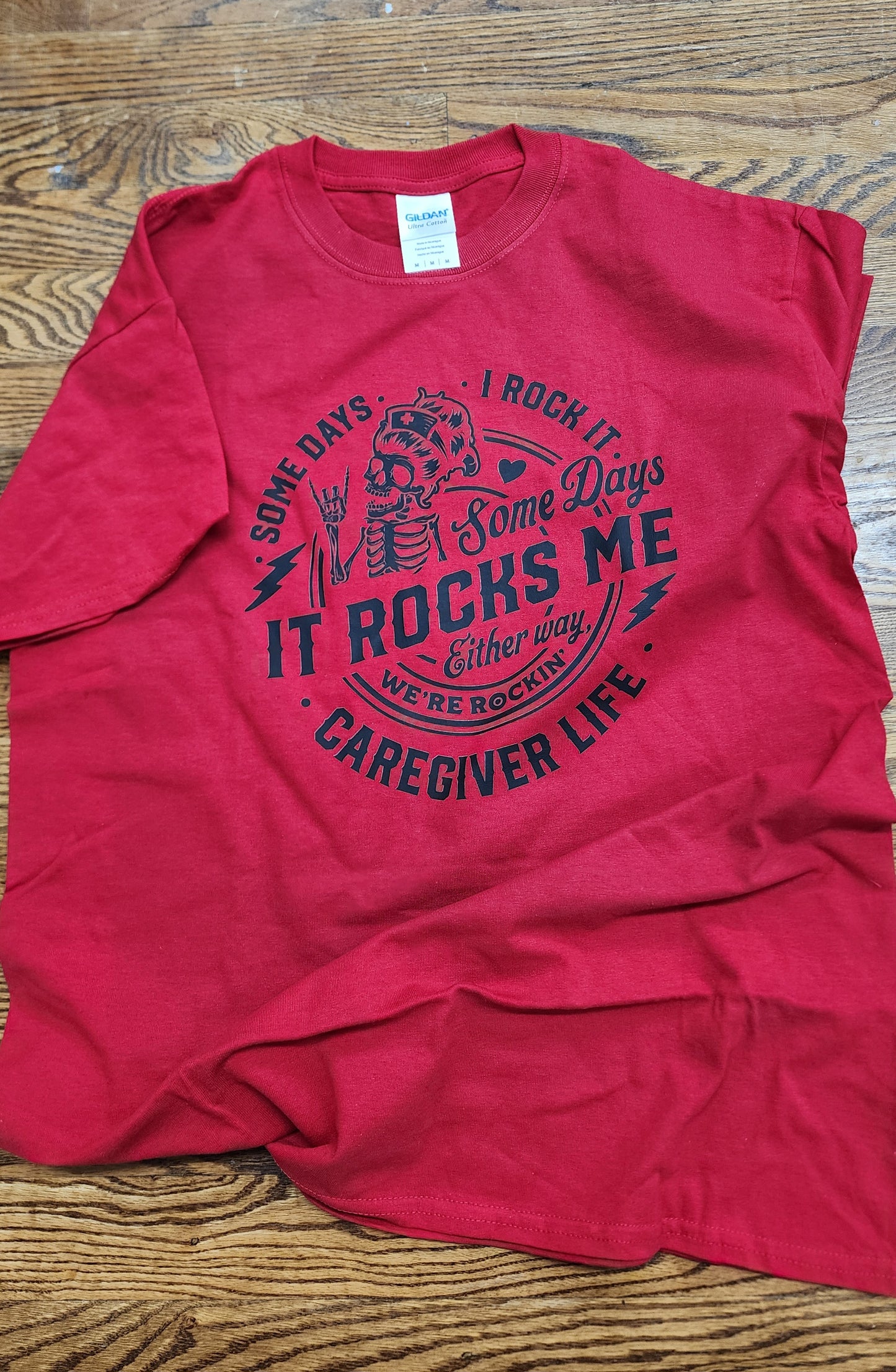 Red t-shirt with black text and graphics supporting the caregiver life