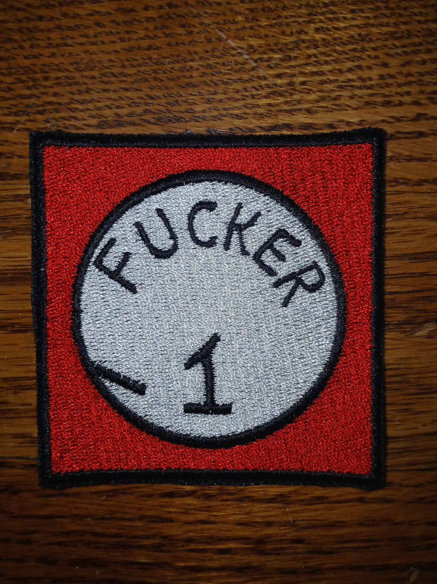 Embroidered patch with 'Fucker 1' design on a red background