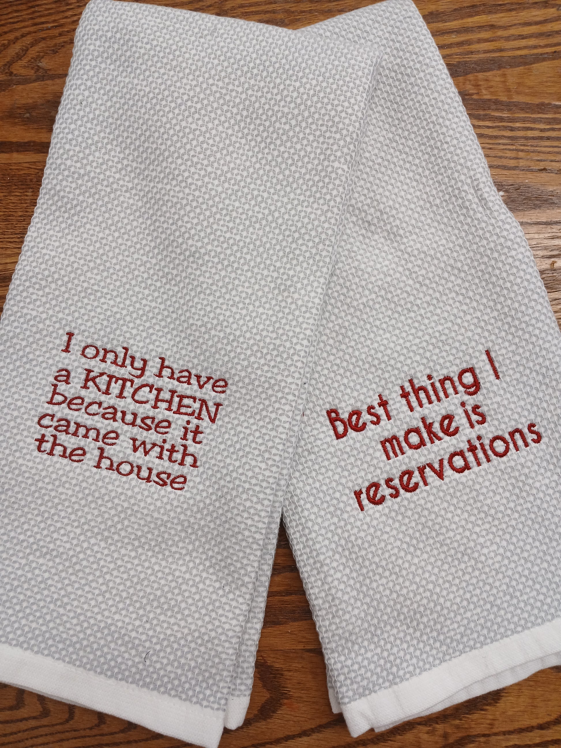 Two gray kitchen towels with red text for the Kitchen newbie