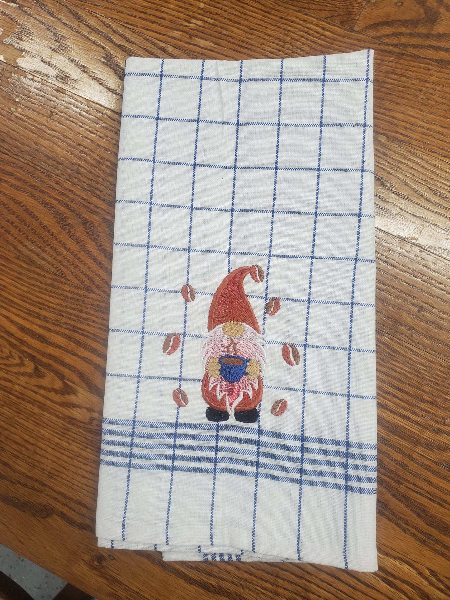 Gnome drinking coffee on kitchen towel with coffee beans