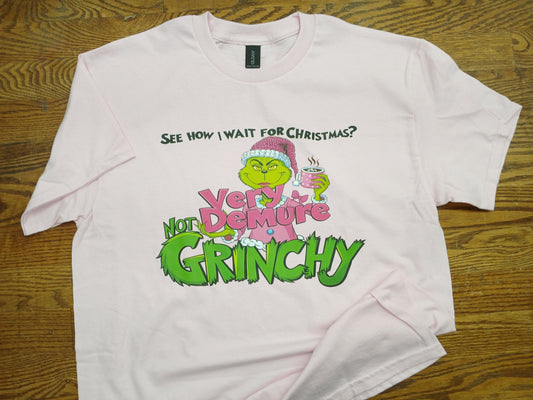 Pale Pink t-shirt with Grinch graphic and text Very demure and not grinchy