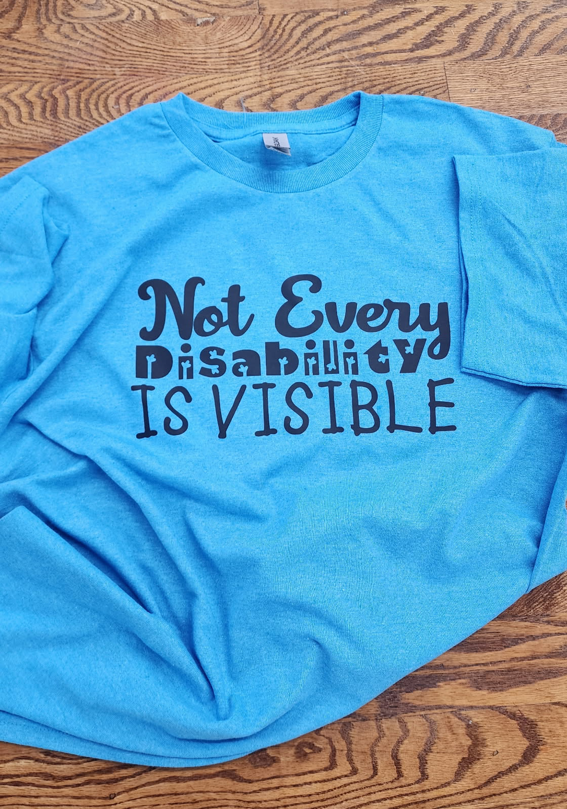 Blue t-shirt with 'Not Every Disability Is Visible' text 