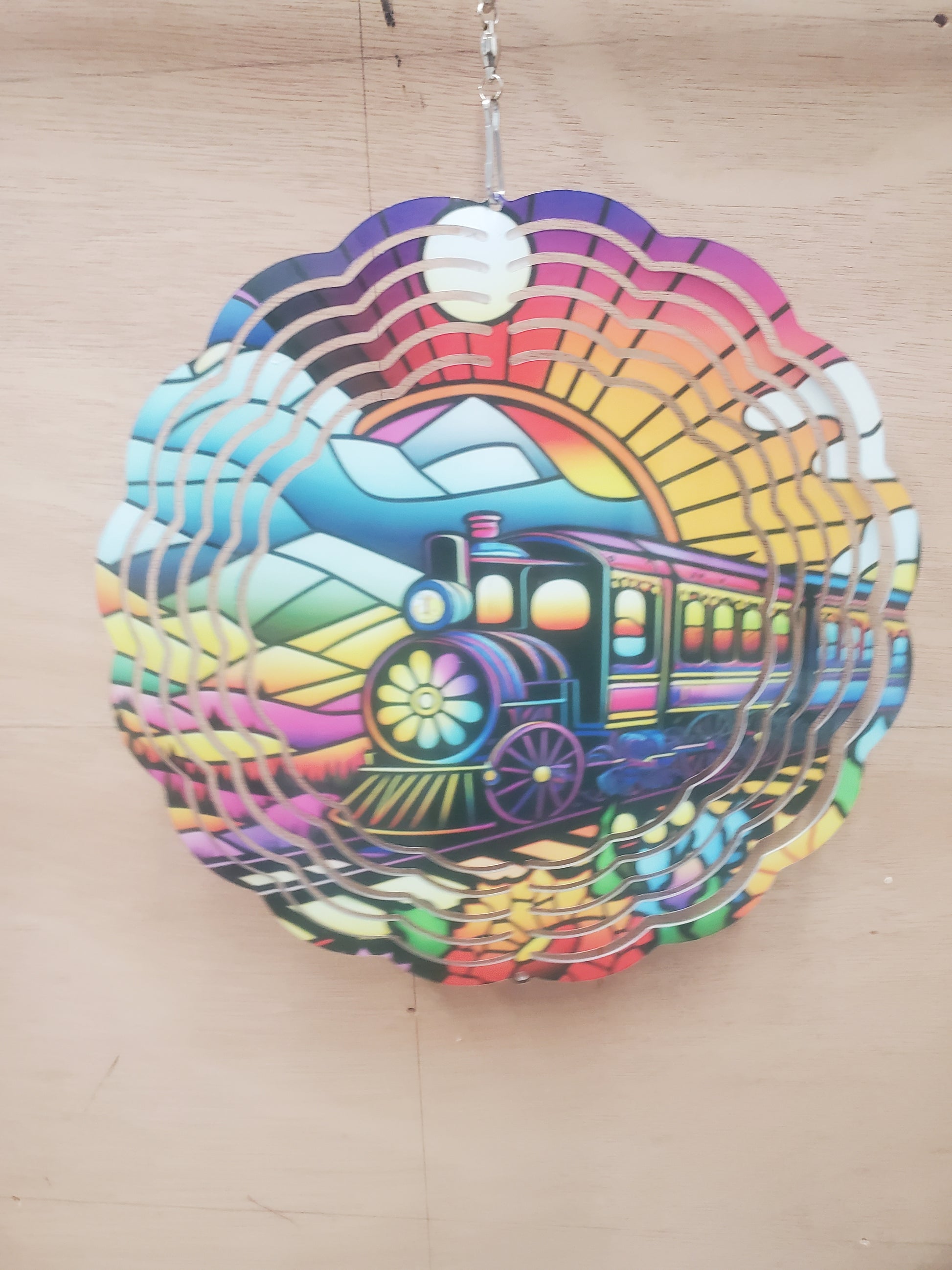 8 inch colorful wind spinner with a train and mountain scene.